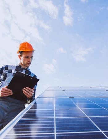 Man worker in the firld by the solar panels